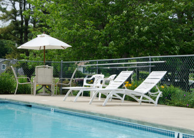 A swimming pool with a white umbrella.