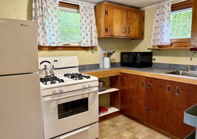A kitchen with a fridge, stove and utensils